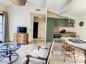 a kitchen with green cabinets and a table and chairs at **LOVELY APARTMENT IN THE CASTLE OF LA REDORTE** in La Redorte