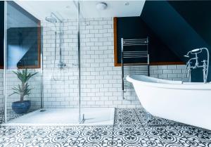 a bathroom with a large tub and a tile floor at The Elm 