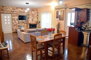 a living room with a table and chairs and a couch at Stone Villa in Korinthos