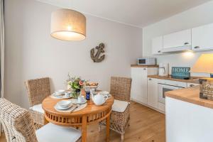 a kitchen and dining room with a wooden table and chairs at Captains Lounge in Eckernförde