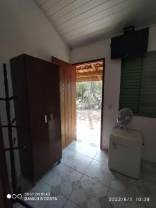 a bathroom with a toilet and a door to a yard at Pousada, Camping e Restaurante Recanto do Surubim in São Roque de Minas