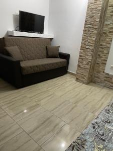 a living room with a couch and a flat screen tv at Vila Vlad in 2 Mai