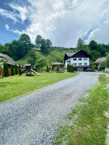 a gravel road with a house and a playground at Casa Violetei in Bran