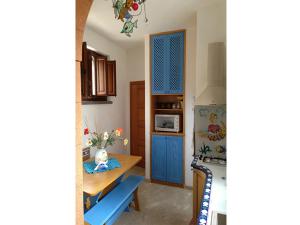 a kitchen with a table and a blue door at CASA CON VERANDA SUL MARE e A 4 MINUTI A PIEDI DALLA SPIAGGIA in Custonaci