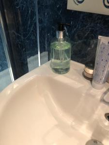 een wastafel in de badkamer met een fles zeep erop bij Strathallan B&B in Inverness +67 foto's