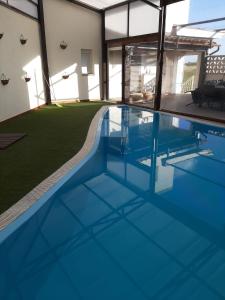 a swimming pool with blue water in a house at Casa Rural La Sureña in Ossa de Montiel