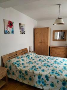 1 Schlafzimmer mit einem Bett mit Blumenbettdecke in der Unterkunft AJARNOLA N14 in Padola