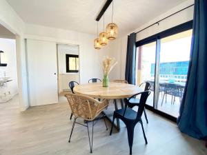 een eetkamer met een houten tafel en stoelen bij Apartamento recién reformado para 6 personas in Port de Pollença