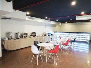 a restaurant with white tables and red chairs at Hotel Boutique Candamo in Lima