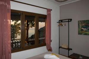 a bedroom with a window with a view of the ocean at Balcony on the Rocks in Agii Saranta