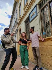 un gruppo di tre persone che si trovano di fronte a un edificio di Fatima Hostel Bogotá a Bogotá