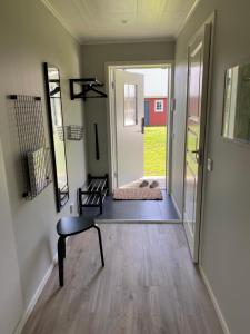 a hallway with a chair and a door to a yard at Skog Fegen nära Ullared in Fegen