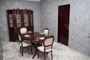 a dining room with a wooden table and chairs at Gulistan Hotel in Dushanbe