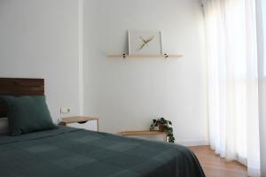 sypialnia z łóżkiem i zegarem na ścianie w obiekcie Beautiful brand new 2 bedroom flat with terrace w Maladze