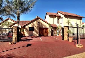 a house with a tennis court in front of it at Pilgrims Delight Guest House in Centurion