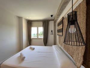 een slaapkamer met een wit bed en een raam bij Apartamento Vela Cambrils Playa in Cambrils