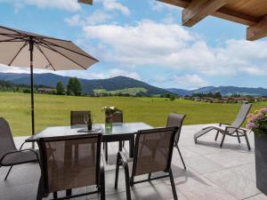 a patio with a table and chairs and an umbrella at Reh4 Appartement in Westendorf