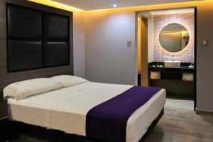 1 dormitorio con 1 cama grande y espejo en Auto-Hotel Playa Linda en Veracruz