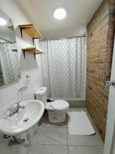 a bathroom with a white toilet and a sink at Hotel 9 de Octubre in Quito