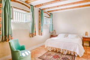een slaapkamer met een bed en een groene stoel bij Finca el Patio in Los Realejos