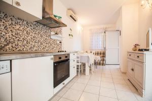 a kitchen with white cabinets and a table in it at Beach Holiday Home Laura in Mimice