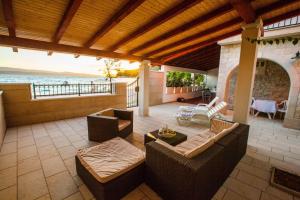 a patio with furniture and a view of the ocean at Beach Holiday Home Laura in Mimice