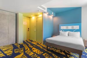 um quarto com uma cama e um tapete azul e amarelo em ibis budget Tbilisi Center em Tbilisi