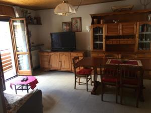 Sala de estar con mesa de comedor y TV en residenza in zona Pontedilegno T02034, en Villa dʼAllegno