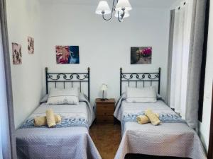 two twin beds in a room with white walls at Villa Maravillas in Nerja +32 photos