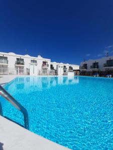 a large swimming pool with blue water at Casa Gil Corralejo San Valentin in Corralejo