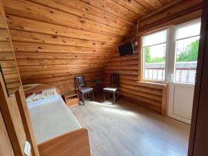 a log cabin with a bed and a window at Vila Aura in Šventoji