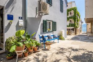 a blue bench in front of a building with plants at Family in Gradac