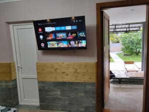 a flat screen tv on a wall in a living room at Homelike Inn in Makhinjauri