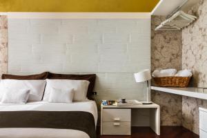 ウーディネにあるBoutique Apartment Casa Angelaのベッドルーム1室(ベッド1台、ランプ付きテーブル付)