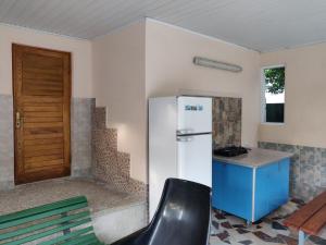 a kitchen with a refrigerator and a table and a chair at Homelike Inn in Makhinjauri