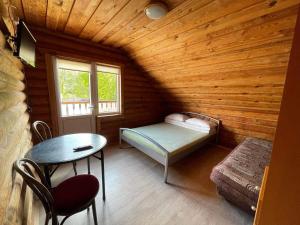 Habitación pequeña con 1 cama en una cabaña de madera en Vila Aura, en Šventoji