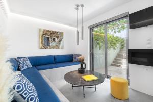 a living room with a blue couch and a table at Los Pistachios in Aegina Town