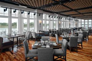 - une salle à manger avec des tables, des chaises et des fenêtres dans l'établissement Beaufort Hotel, à Beaufort