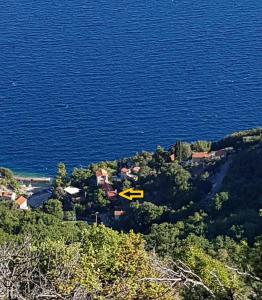 een eiland in het midden van het water met een gele pijl bij Apartments Šmit in Cres
