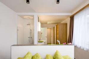 a bathroom with a shower and a couch with pillows at Apart Simon Seefeld in Seefeld in Tirol