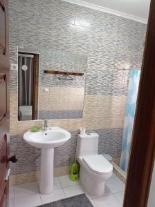 a bathroom with a toilet and a sink at Residencial Brigada in Santo António
