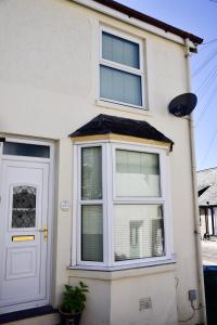 a white house with a window and a door at Fern Villa in Conwy