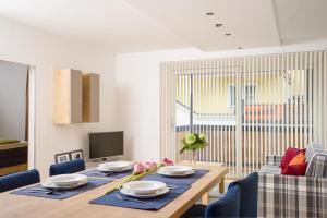 a dining room with a table and chairs and a television at Apart Simon Seefeld in Seefeld in Tirol