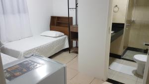 瓜拉帕里的住宿－Enseada Suítes，小房间设有床和卫生间