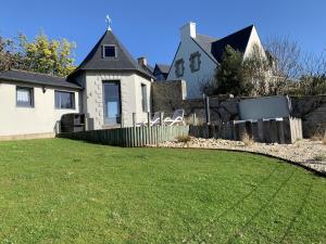 uma casa com um quintal com uma cerca em Studio de Charme "Le Coquillage " Jacuzzi privatif em Pléneuf-Val-André