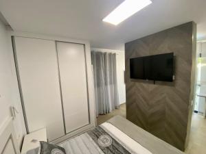 a bedroom with a tv on a wall with a bed at Loft Deluxe Raquel in Conil de la Frontera