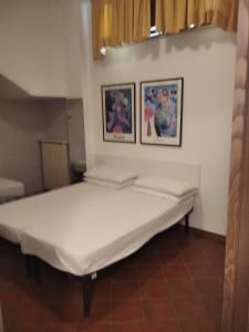 a large bed in a room with two pictures on the wall at Darecco house in Cesenatico