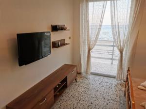 a bedroom with a flat screen tv on a wall with a window at Anatolikos Rooms in Alykes