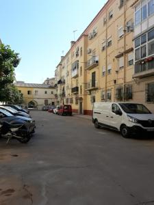 uma carrinha branca estacionada num parque de estacionamento ao lado de edifícios em Apartamento La escapada em Málaga