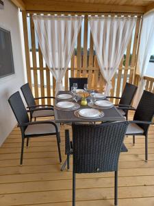 uma mesa preta e cadeiras num deque em CHARTA Mobile Home Meon em Drage